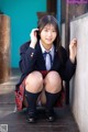 A young woman in a school uniform posing for a picture.