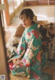 A woman in a kimono sitting on the floor.