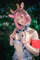 A woman with pink hair wearing a cow costume.