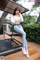 A woman sitting on a chair on a wooden deck.