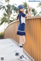 A woman in a blue and white uniform is posing for a picture.