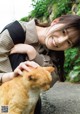 A woman is petting a cat on the street.