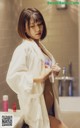 A woman in a bathrobe standing in a bathroom.