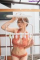 A woman in a red lingerie holding a white hanger.