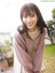 A woman in a pink sweater posing for a picture.