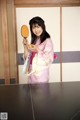 A woman in a pink kimono holding a mirror.