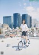 A woman riding a bike on top of a roof.