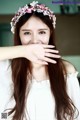 A woman with long brown hair wearing a flower crown.