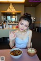 A woman sitting at a table with two bowls of food.