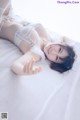 A woman laying on top of a bed in lingerie.