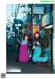 A couple of women standing next to each other on a street.