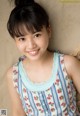 A young girl laying on a bed smiling at the camera.