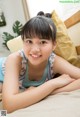 A young girl laying on a bed smiling at the camera.